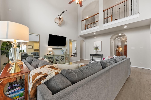 8603 Rexford Cove Ct, Richmond, TX 77407 - living room with a ceiling fan, arched walkways, wood finished floors, baseboards, and a high ceiling