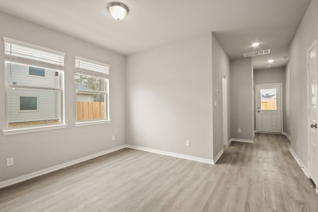 empty room featuring visible vents, baseboards, and light wood-style floors