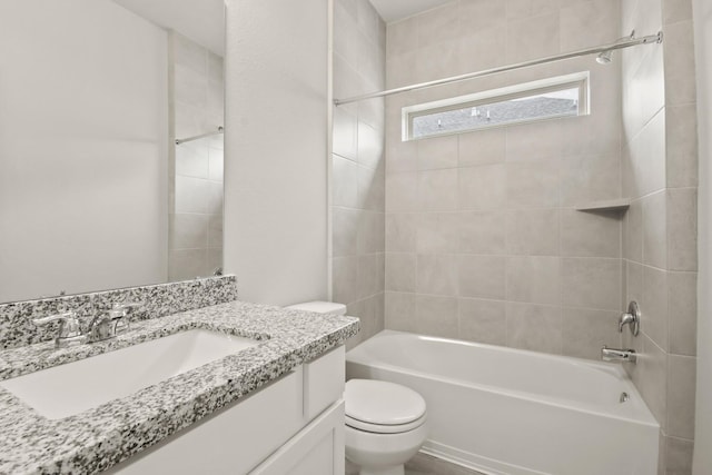 bathroom featuring toilet, vanity, and bathtub / shower combination