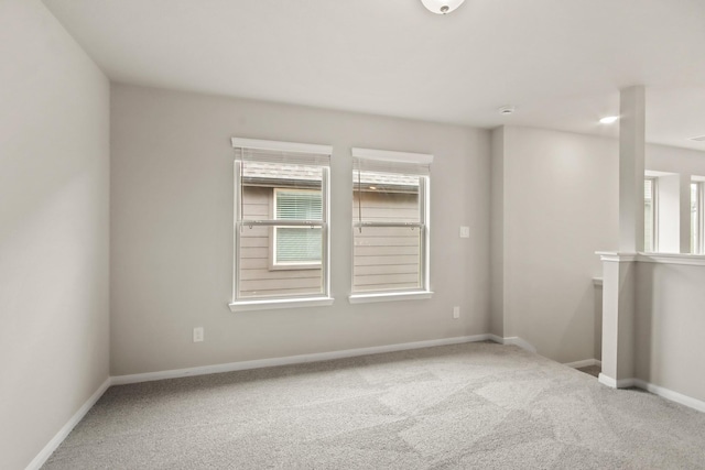 empty room featuring baseboards and carpet floors