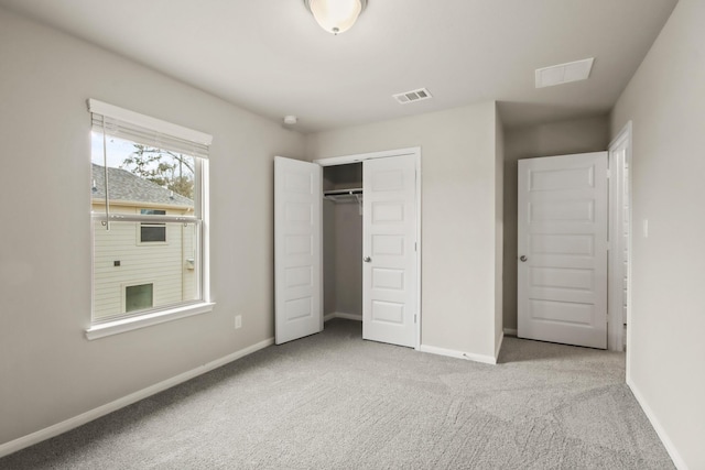 unfurnished bedroom featuring a closet, carpet flooring, visible vents, and baseboards