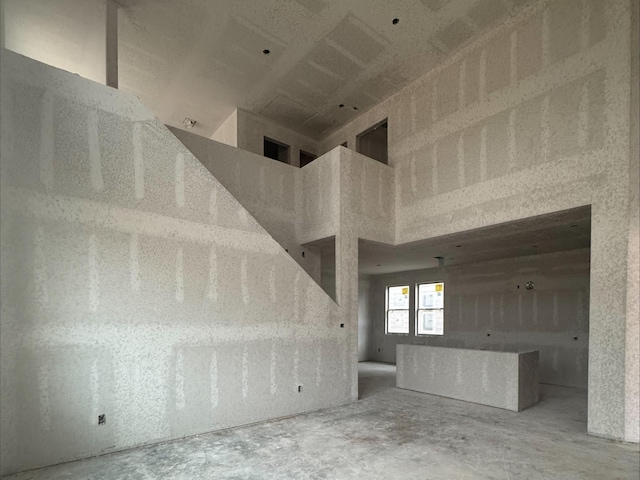 unfurnished living room with a towering ceiling
