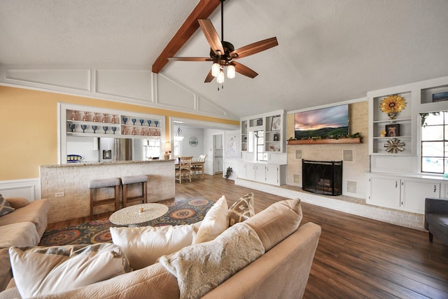 living room with built in features, a brick fireplace, and a decorative wall