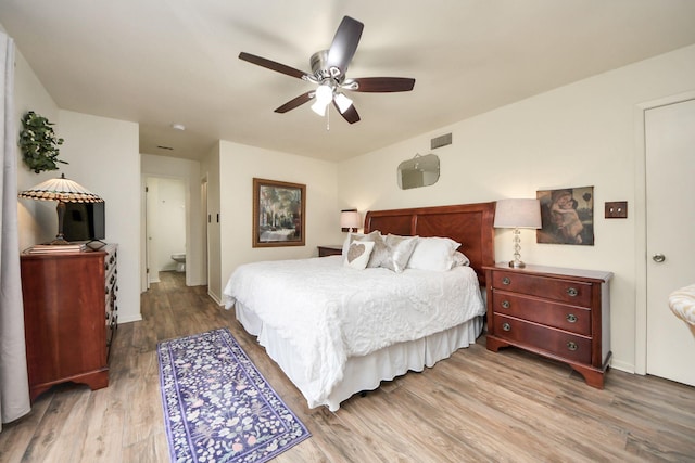 bedroom with ceiling fan, wood finished floors, visible vents, and baseboards