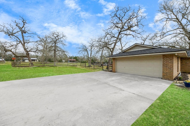 garage featuring concrete driveway and fence