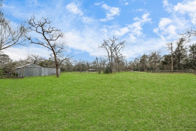 view of yard with an outbuilding and fence