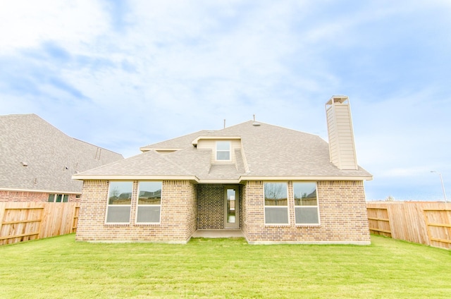 back of house featuring brick siding, a fenced backyard, and a yard