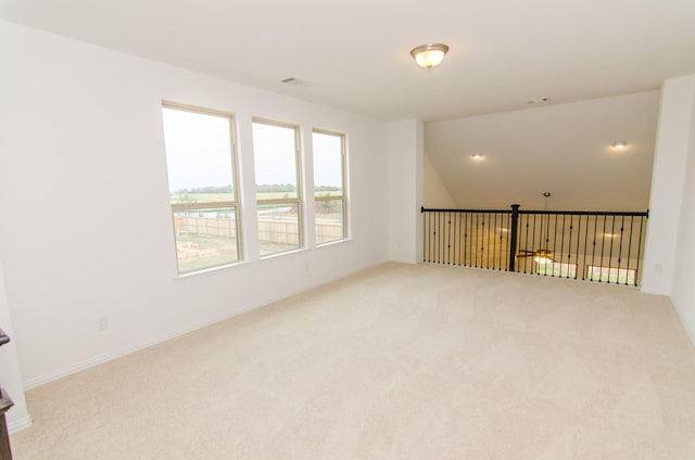 carpeted empty room featuring baseboards and visible vents