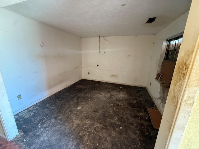 spare room with a textured ceiling