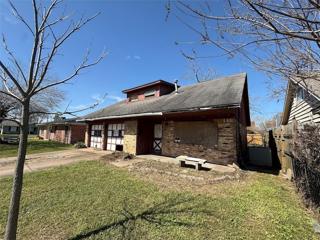 view of front of house featuring a garage, brick siding, concrete driveway, fence, and a front yard