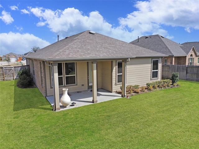 rear view of property with a patio area, a fenced backyard, a shingled roof, and a yard