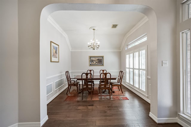 dining room with crown molding, arched walkways, visible vents, and dark wood-style flooring