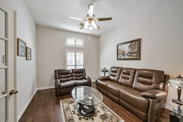 living room with baseboards, dark wood-type flooring, and ceiling fan