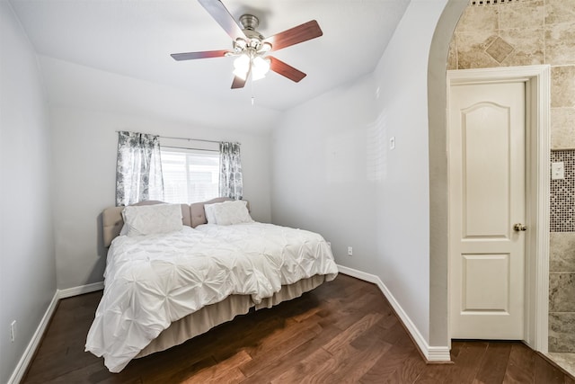 bedroom with lofted ceiling, baseboards, and dark wood-style flooring