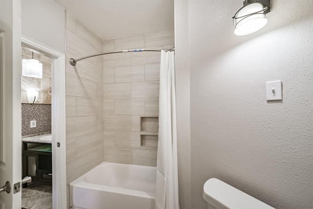 full bath featuring toilet, shower / tub combo with curtain, and a textured wall