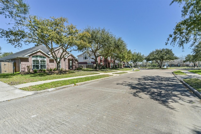 view of street with a residential view, curbs, street lighting, and sidewalks