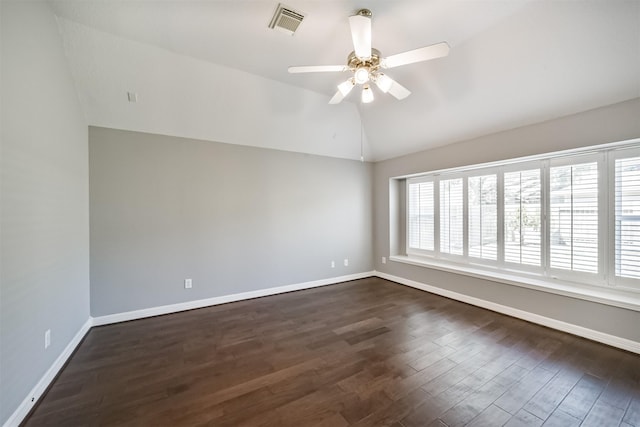 empty room with baseboards, lofted ceiling, dark wood finished floors, and a ceiling fan