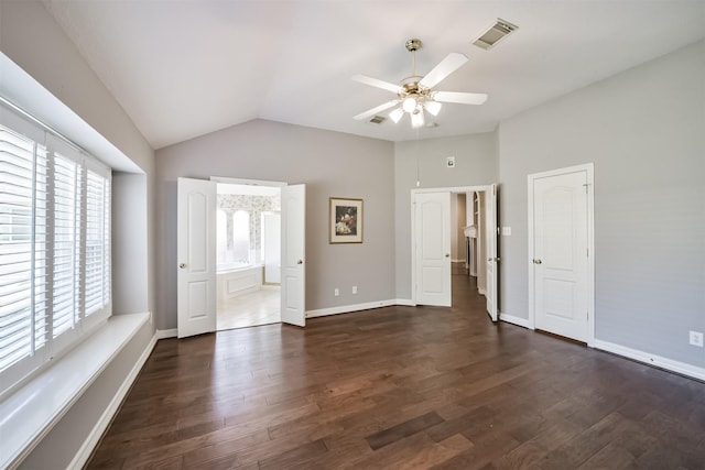 unfurnished bedroom with dark wood-style floors, visible vents, baseboards, and vaulted ceiling