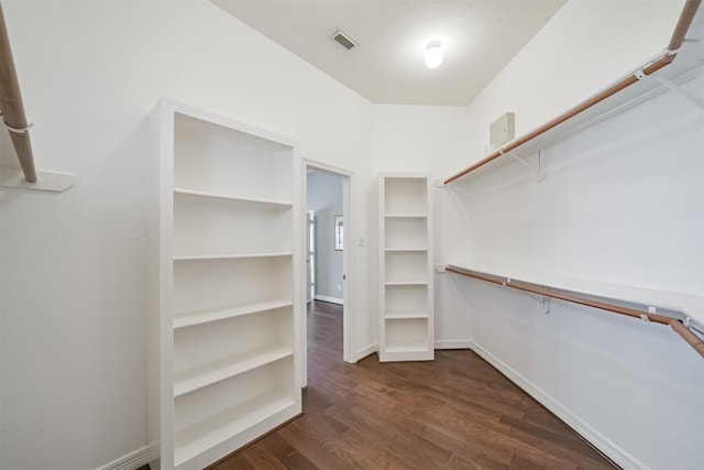 walk in closet featuring visible vents and dark wood-type flooring