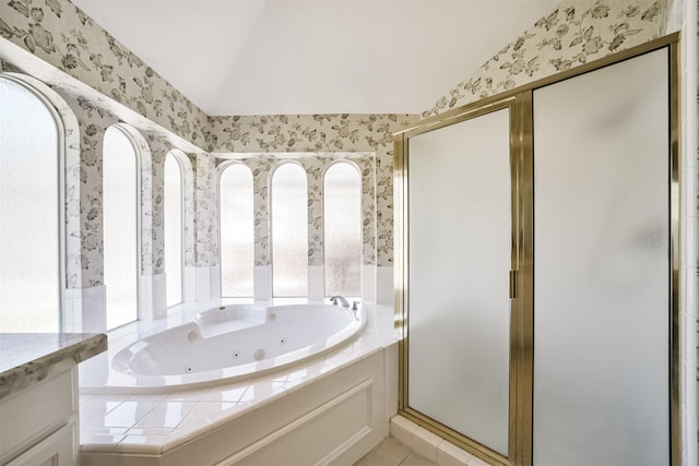 bathroom with a shower stall, a jetted tub, wallpapered walls, and lofted ceiling