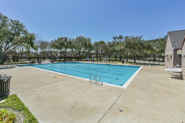 pool with a patio area and fence