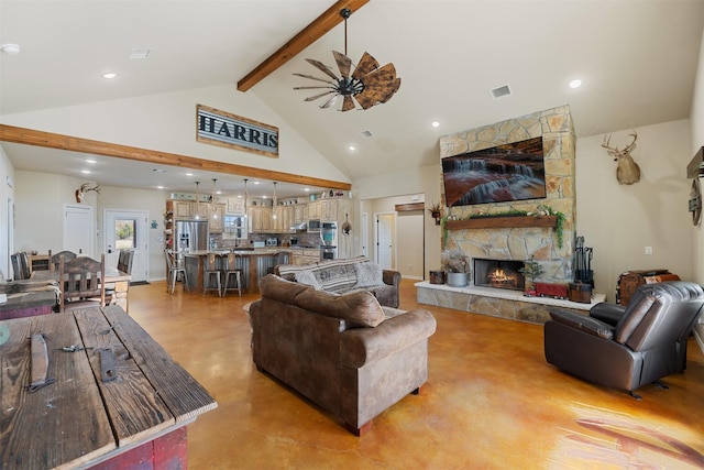 living room featuring visible vents, a ceiling fan, beamed ceiling, a fireplace, and high vaulted ceiling