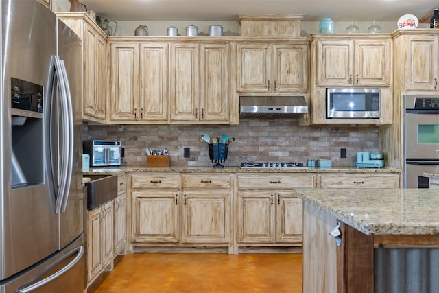 kitchen with decorative backsplash, appliances with stainless steel finishes, light stone counters, light brown cabinets, and exhaust hood