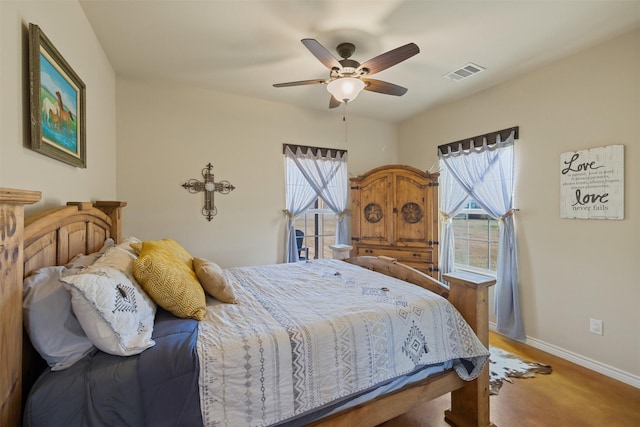 bedroom with a ceiling fan, visible vents, baseboards, and multiple windows