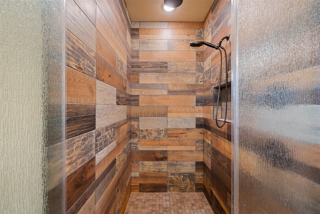 bathroom with a stall shower and wooden walls