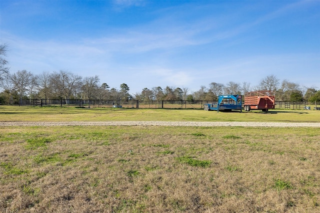 view of yard featuring a rural view, fence, and an outdoor structure