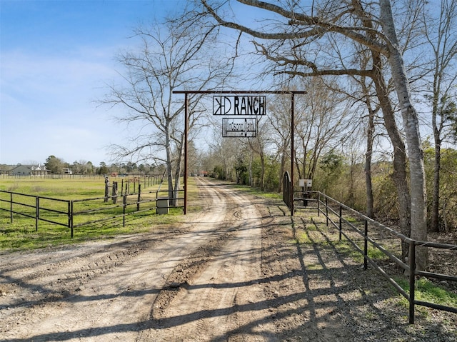 view of road featuring a rural view, a gated entry, and dirt driveway