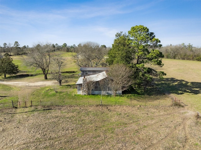 view of yard featuring driveway, a rural view, and fence