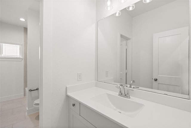 bathroom featuring baseboards, vanity, toilet, and tile patterned floors