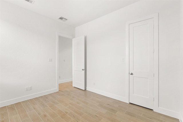 unfurnished bedroom with visible vents, light wood-style flooring, and baseboards