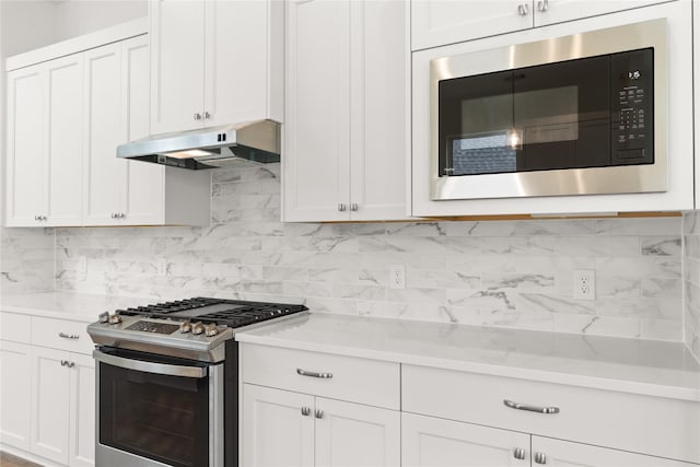 kitchen featuring stainless steel range with gas cooktop, tasteful backsplash, white cabinets, built in microwave, and under cabinet range hood