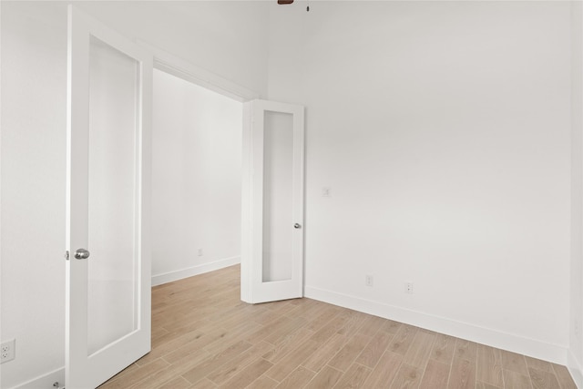 unfurnished room with light wood-style flooring and baseboards