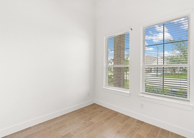 empty room featuring baseboards and wood finish floors