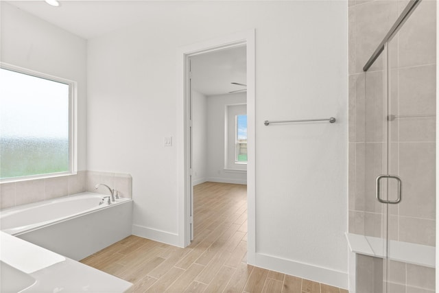 bathroom with a stall shower, plenty of natural light, and wood tiled floor