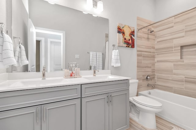 bathroom with bathing tub / shower combination, a sink, double vanity, and toilet