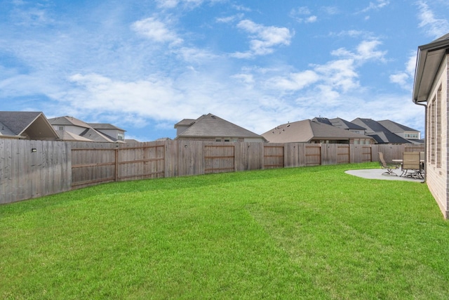 view of yard with a residential view, a fenced backyard, and a patio