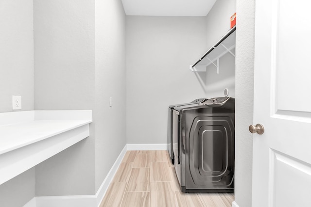 washroom featuring baseboards, independent washer and dryer, and laundry area