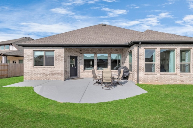 back of property with brick siding, fence, a patio, and a shingled roof
