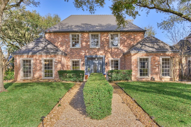 colonial house featuring brick siding and a front lawn