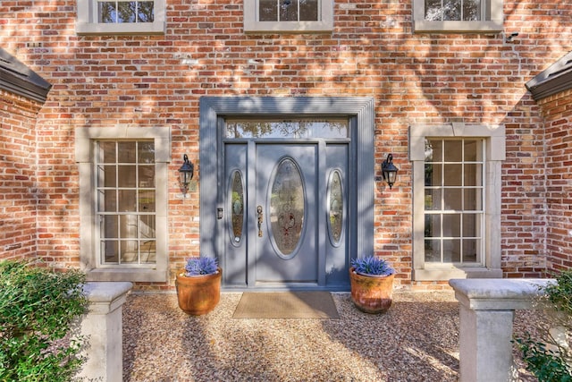 entrance to property featuring brick siding