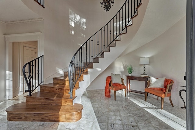 stairs with marble finish floor and a high ceiling