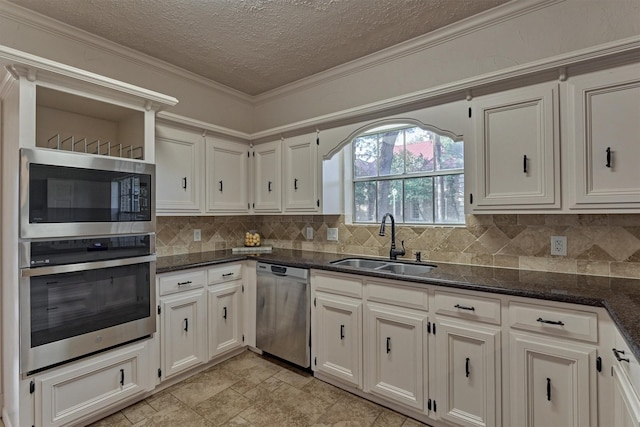 kitchen featuring dark stone counters, stainless steel appliances, tasteful backsplash, and a sink