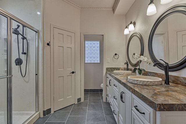 bathroom with double vanity, a shower stall, toilet, and a sink