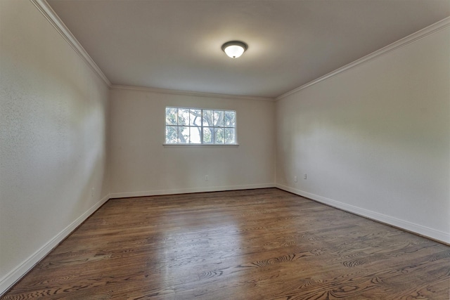 spare room featuring crown molding, baseboards, and wood finished floors