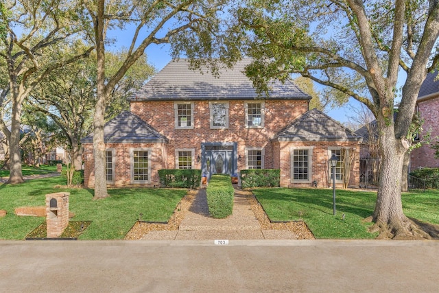 view of front of house featuring a front yard and brick siding