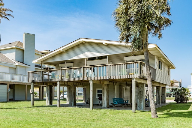 rear view of property featuring a carport, a lawn, and a patio area